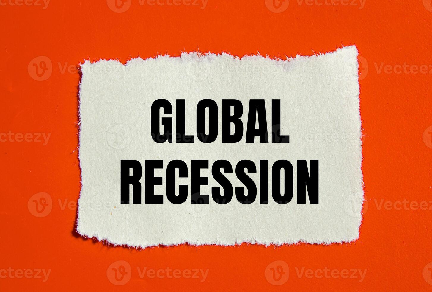 Global recession message written on ripped torn paper piece with orange background. Conceptual global recession symbol. Copy space. photo