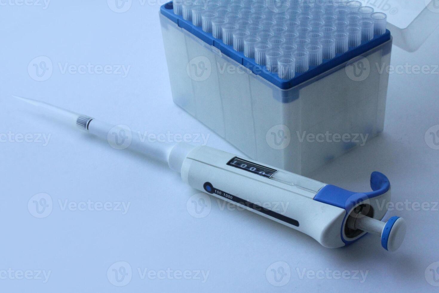 a set of plastic pipette tips in a stand. A blue tip for scientific experiments in a box. microbiological pipette for the genetic laboratory. photo