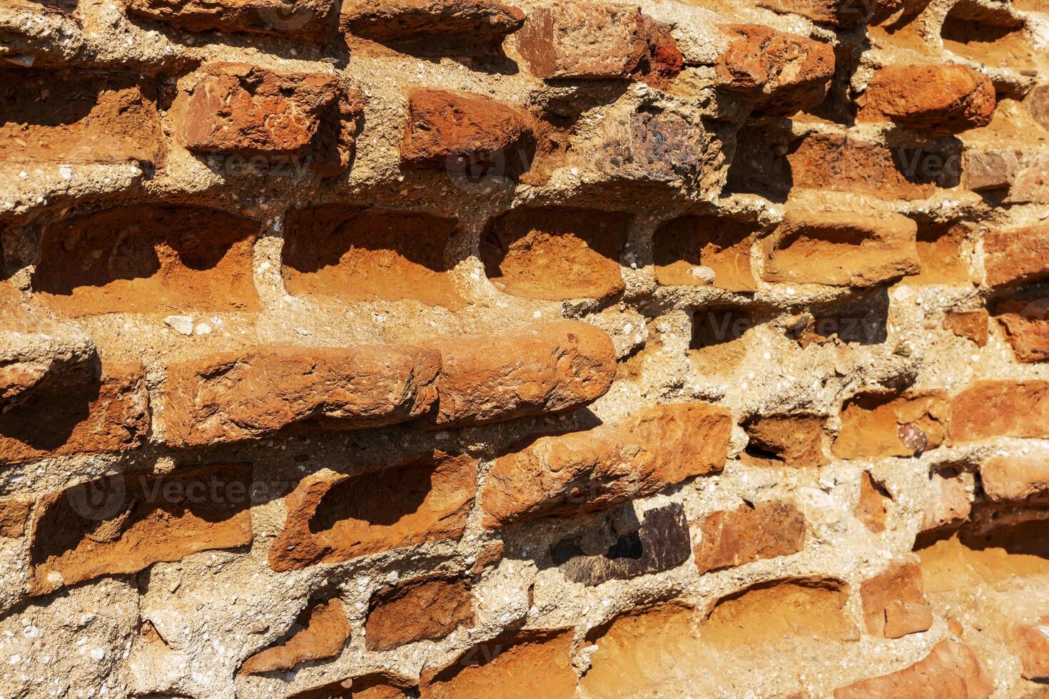 Old brick wall illuminated by the sun's rays photo