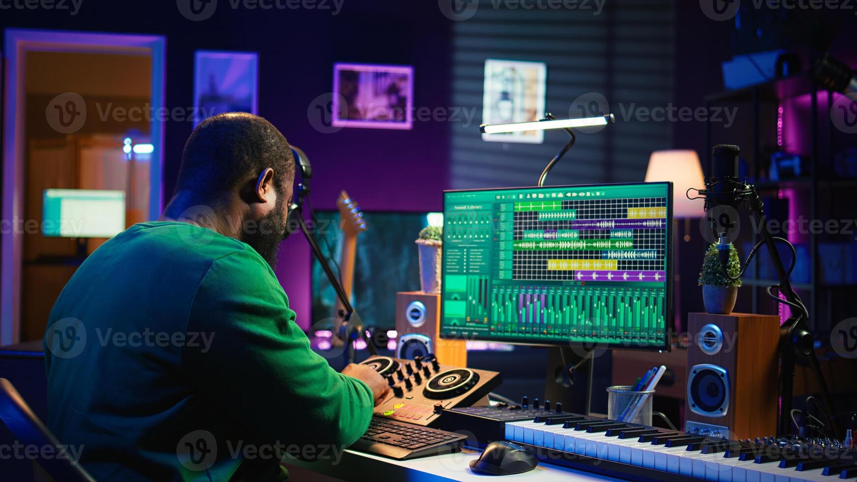 African american composer creating a new track for a project, using professional production pc interface in his home studio. Creative artist songwriter producing music with sound effects. Camera B. photo