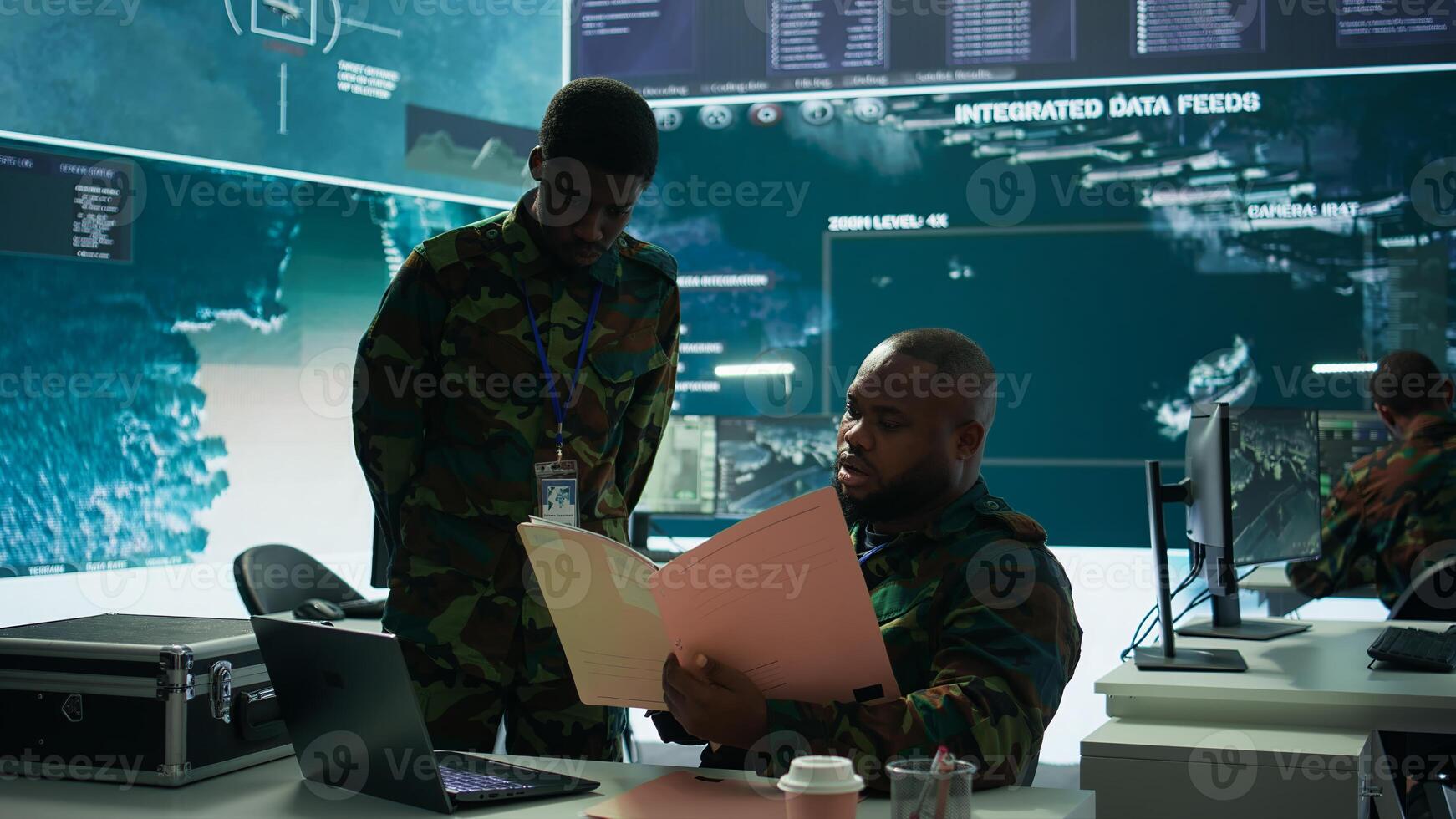 Angry army expert in a command post power base monitors satellite footage, yelling at soldier and throwing papers. Frustrated officer looks at real time data for operational success. Camera B. photo