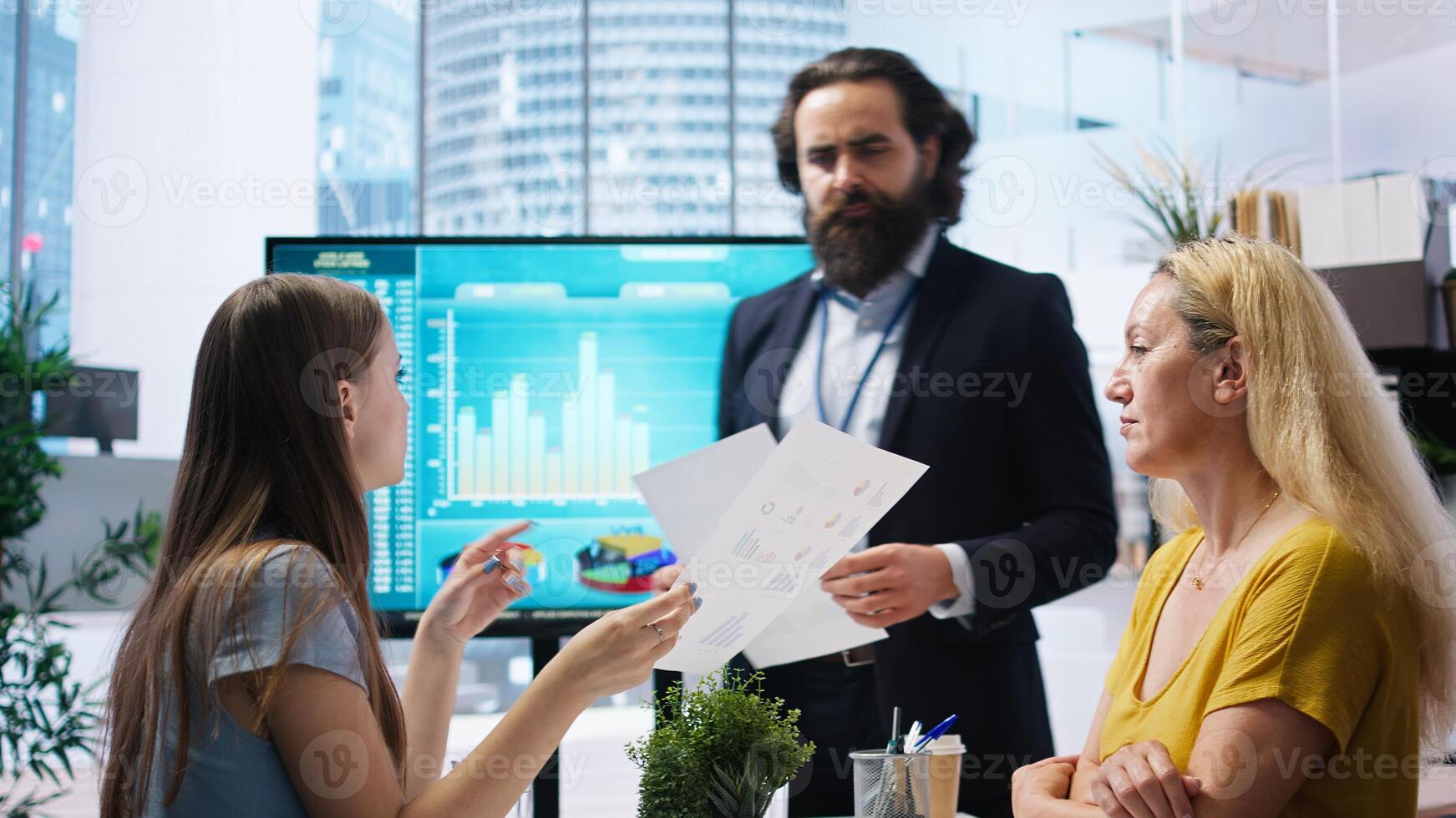 Financial advisor showing statistical graphs on big screen to customers, analyzing market trends to optimize income. Family members checking investment plan on display made by consultant, camera A photo