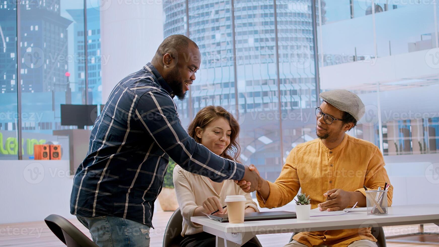 Client and realtor studying architectural plans for the property layout, evaluating investment opportunity at the end of an office tour. Studying blueprints during a meeting with salesman. Camera A. photo