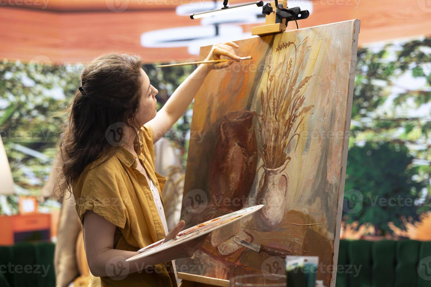 Skilled woman painting an artwork with colorful paints mixed on a palette, creating a beautiful creative paintwork with a certain painting technique in her atelier. Artist mixing watercolor. photo