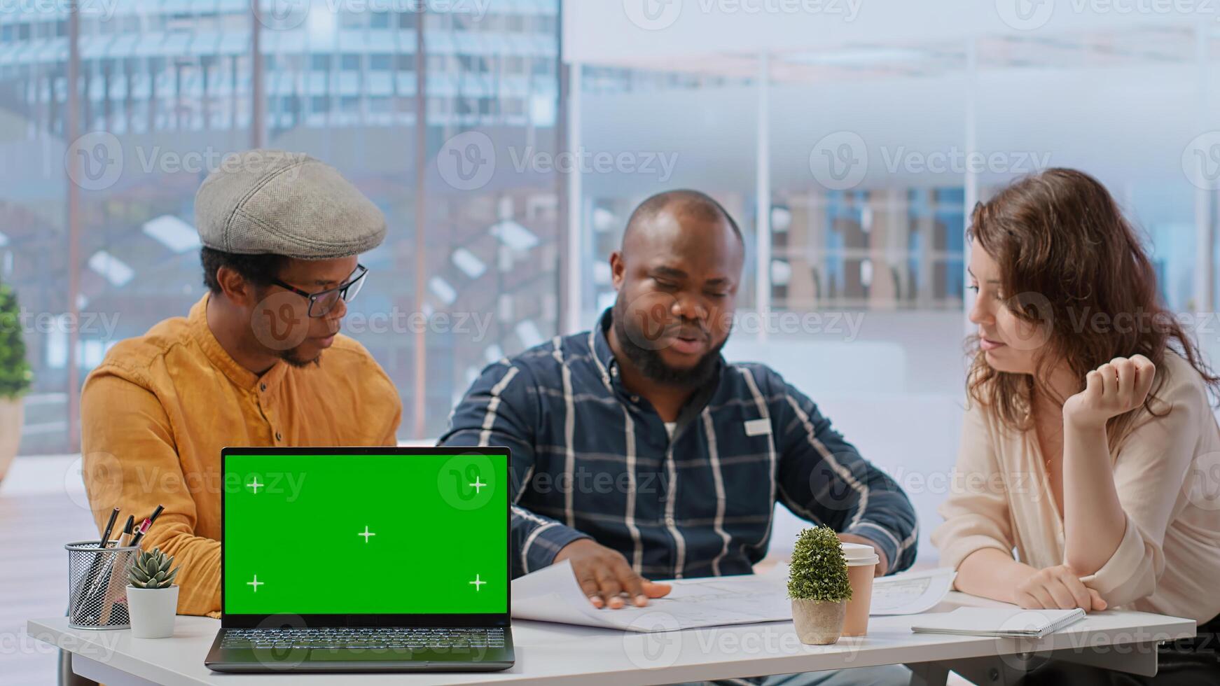 Real estate agents offering a contract to client next to green screen, presenting high class office space blueprints. Realtors negotiating terms with businessman, property investment. Camera B. photo