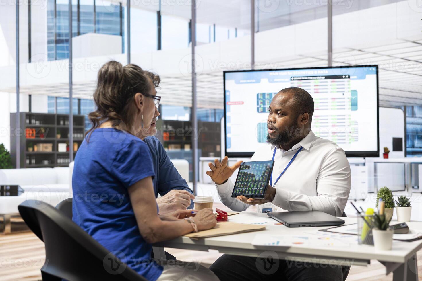 Elderly couple consulting with a financial advisor to explore beneficial retirement plans, securing life savings and pension planning. Looking into banking options for finances. photo