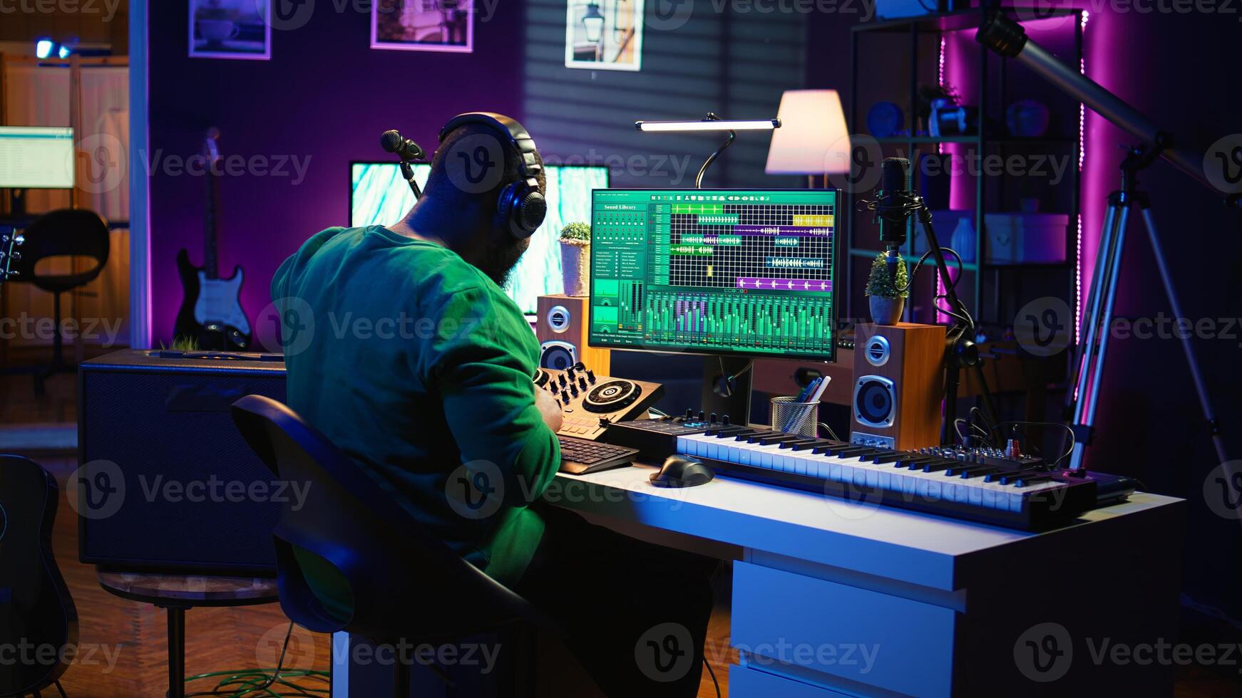 Sound engineer mixing and mastering new music on console and daw software in home studio, twisting pre amp knobs. Talented composer producing songs for the industry. Camera B. photo