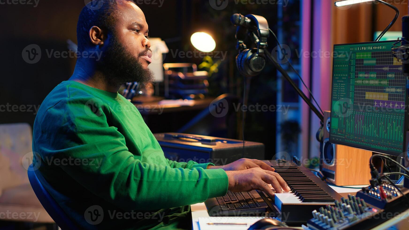Talented artist composing new lyrics for his tracks and recording music with audio devices in his home studio. Singer composer writes melodic material by taking notes and creating rhymes or songs. Camera A. photo