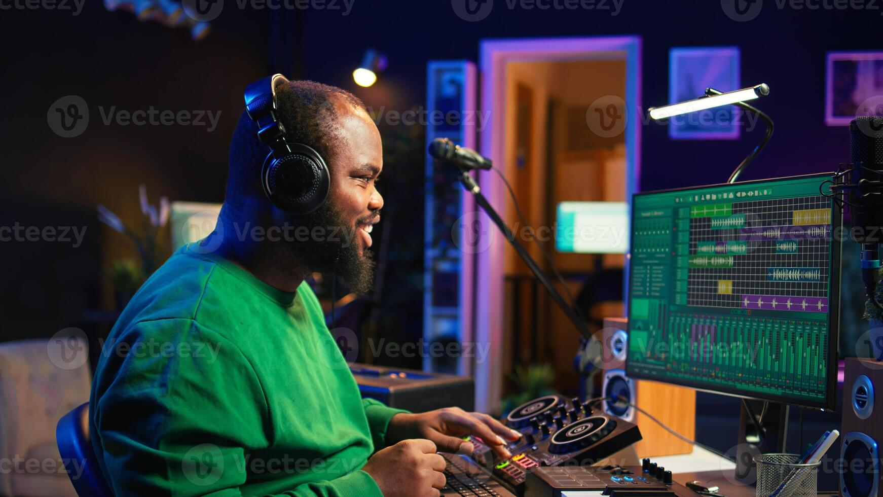 Young musician twisting knobs and mixing tunes with a console, following record settings on a digital software interface. Artist composer producing new music hits in his home studio. Camera B. photo
