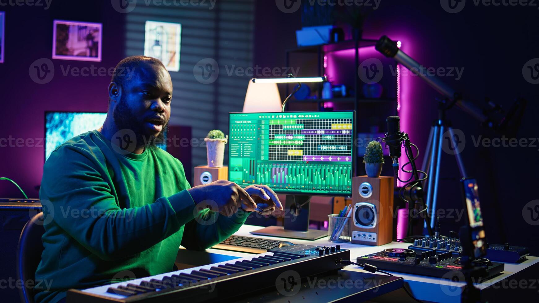 Musician doing online paid classes to help people play piano notes, teaching lessons from his home studio and recording tutorials. Musical instructor playing midi controller keyboard. Camera B. photo