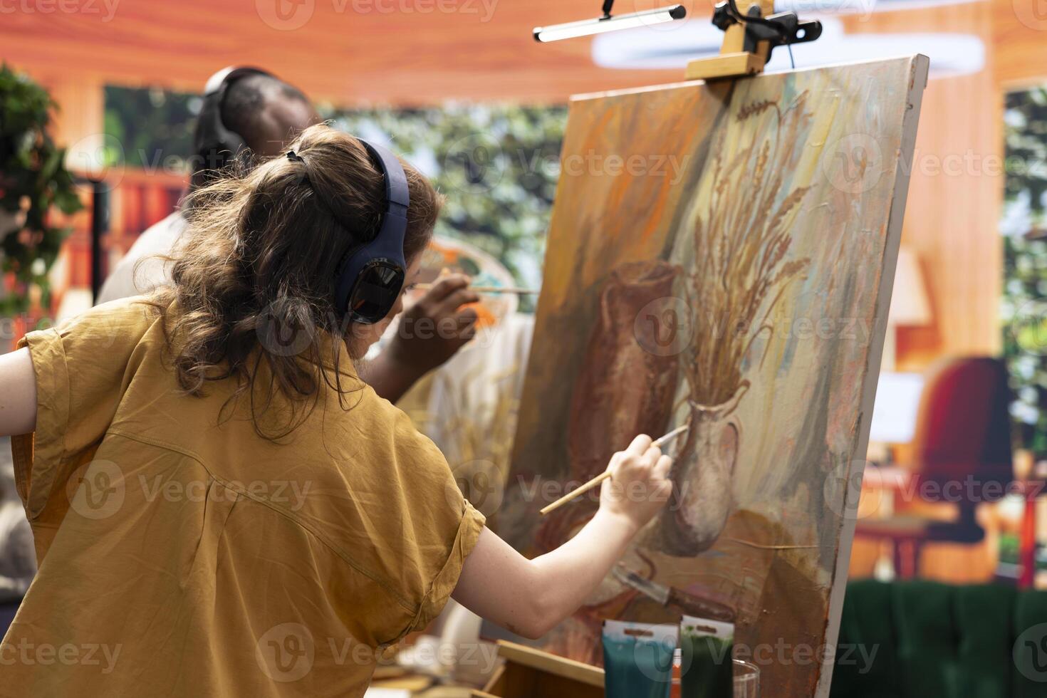 Diverse painters applying watercolor paint with brushstrokes for a certain technique, working together on colorful artwork creation for the gallery. Man and woman enjoying artistic hobby. photo