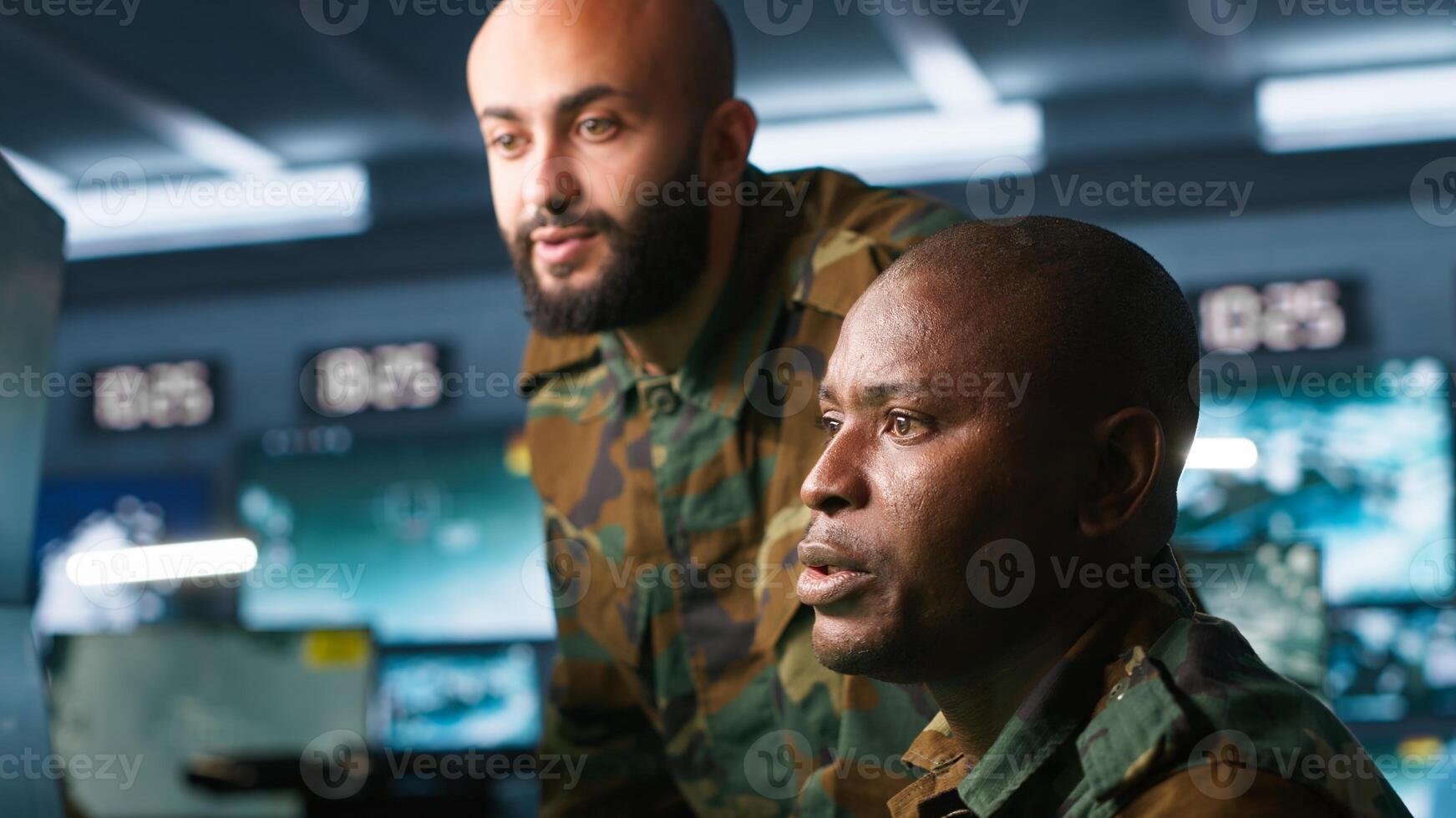 Army unit working in governmental facility next to colleague, operating surveillance monitoring tech with digital equipment. African american man doing job in base of operations, camera A photo