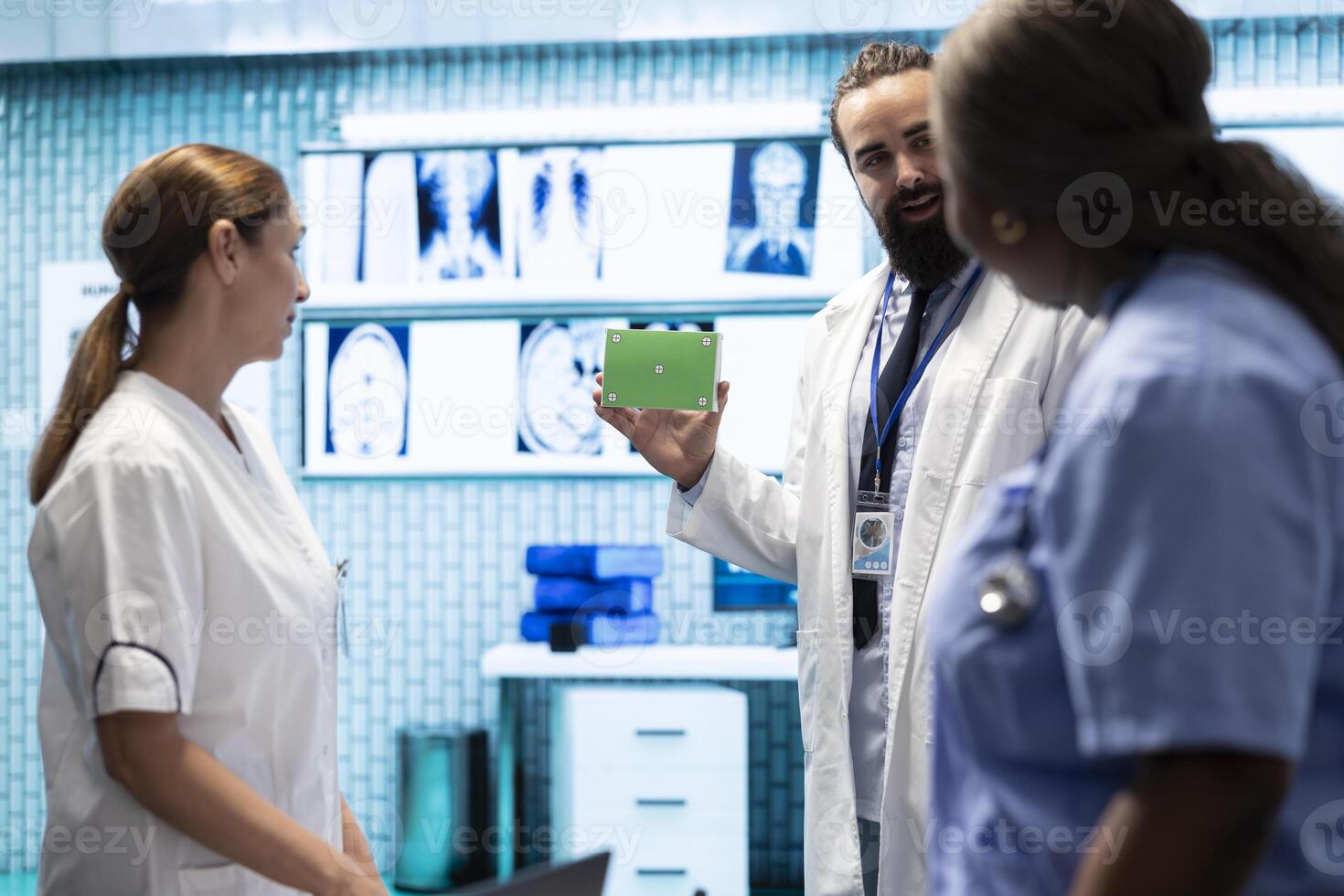 Doctor presenting a box with isolated mockup screen during a meeting for disease prevention, conducting detailed analytics and control of x ray scans in a private clinic. Radiology department. photo