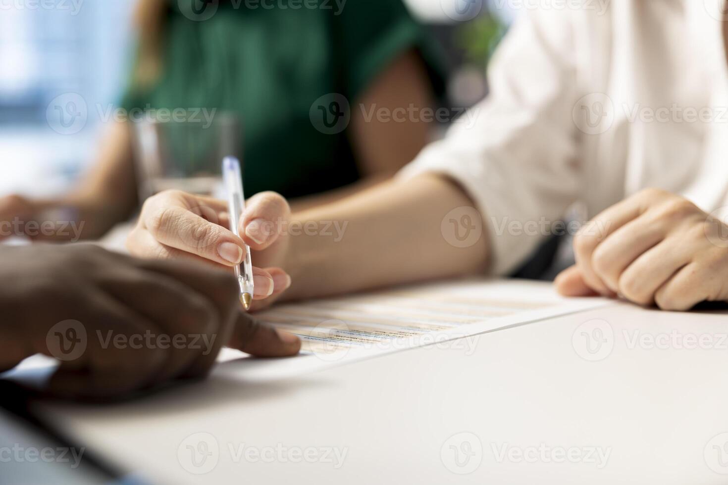 HR specialist signing contract after ensuring job candidate possesses necessary qualifications fitting for company culture. Close up of recruiter checking salary package and other benefits paperwork photo
