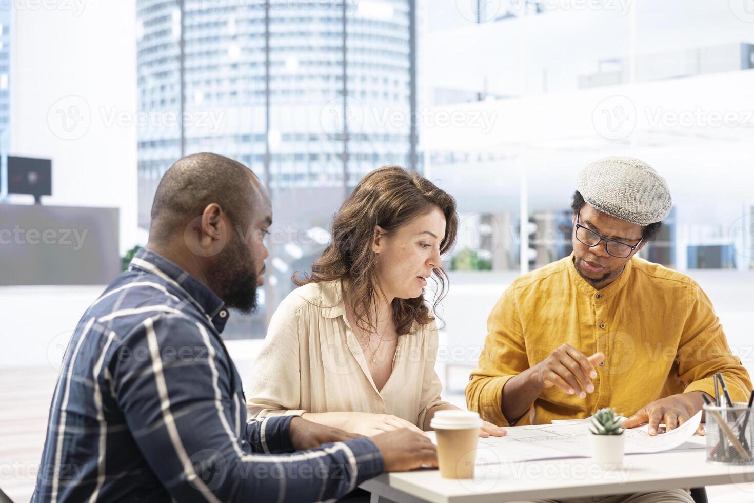 Business woman exchanging building and renovation ideas with a realtor, working together to establish rental contract terms for a big property investment. Analyzing detailed blueprints. photo