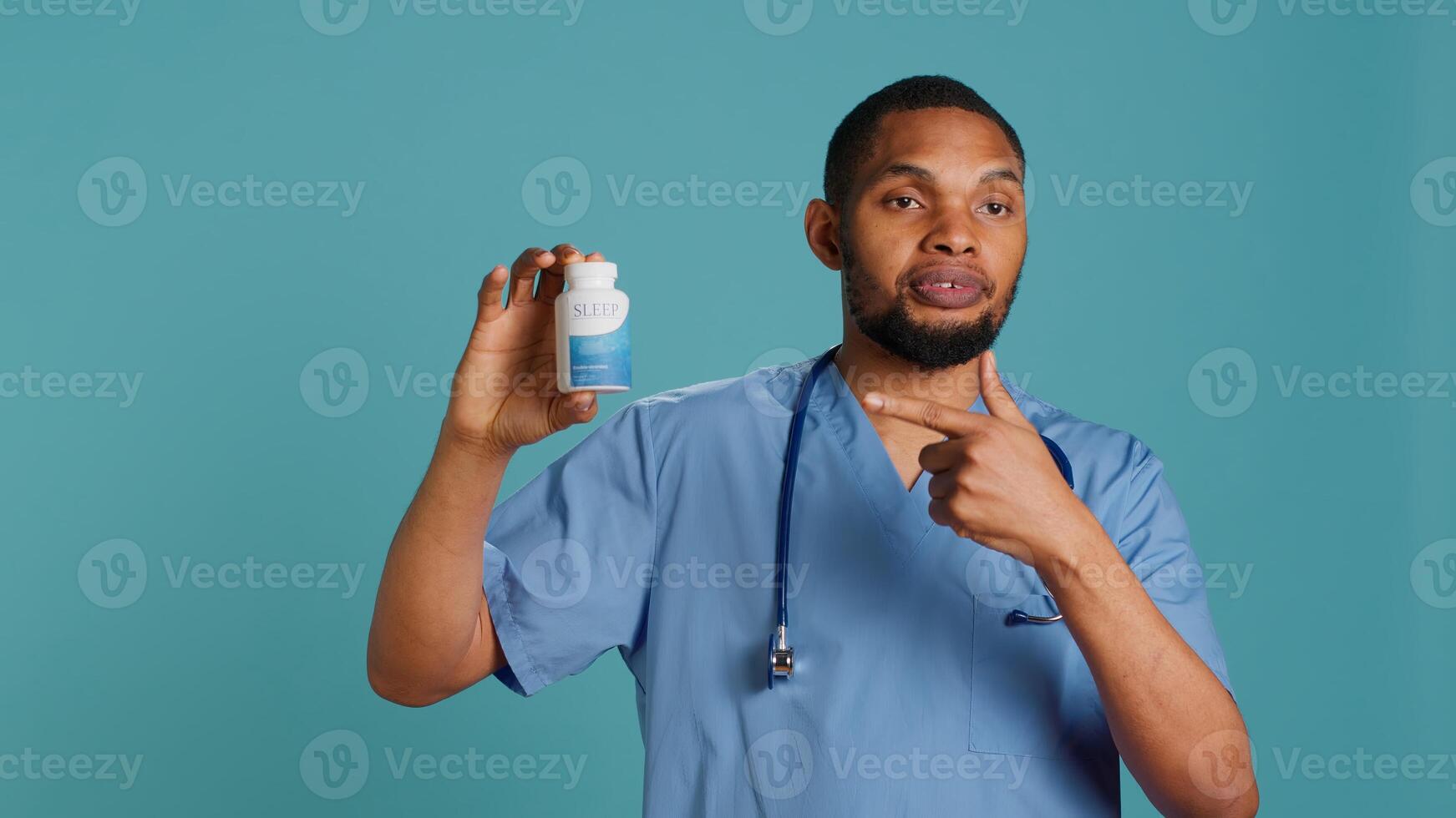 Portrait of hospital staff member holding sleep deprivation medicine for insomniacs, studio background. Doctor recommending pill bottle for patients with sleep disorder, camera A photo