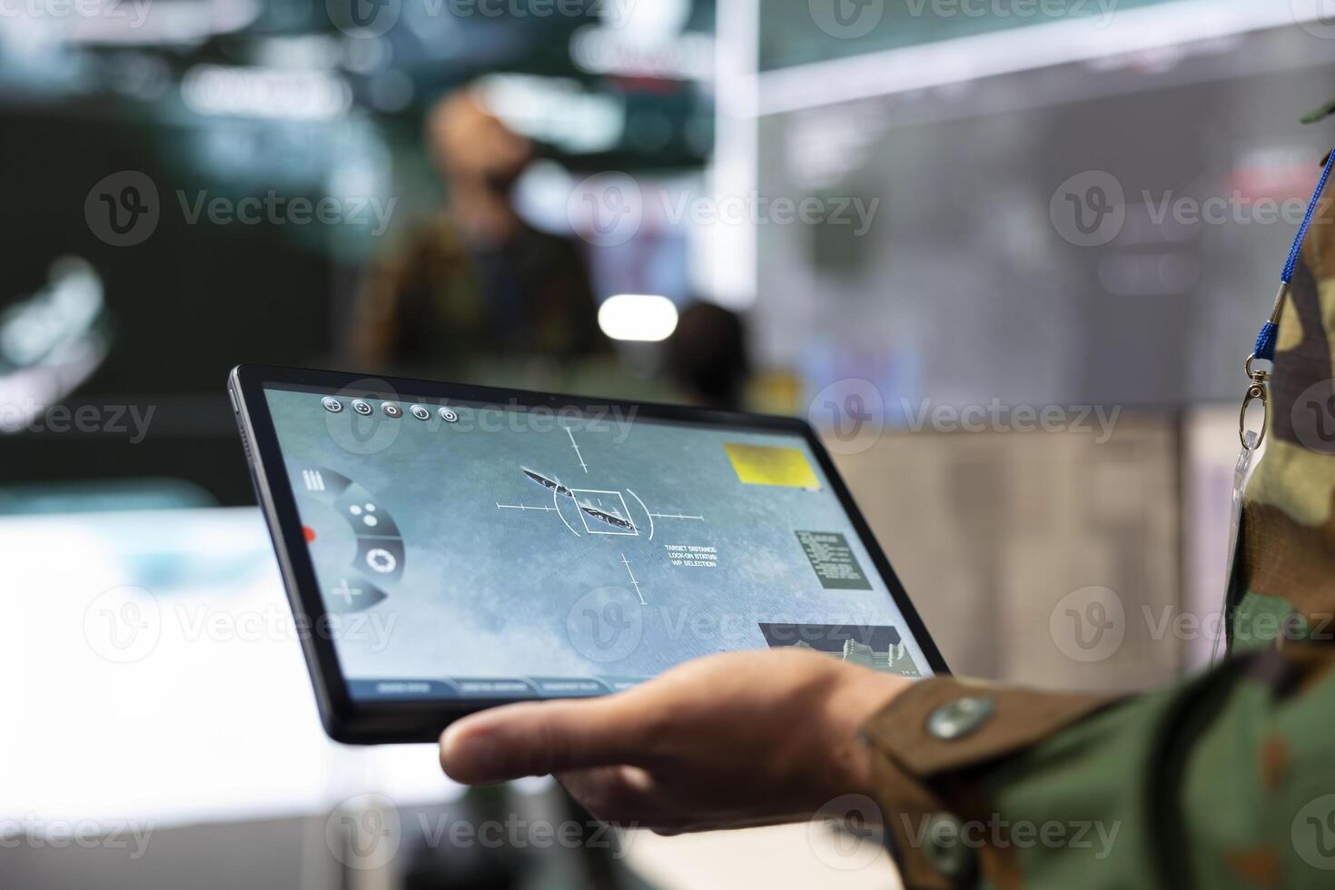 Army IT professional employing a satellite world map with location tracking system on his tablet, monitoring CCTV surveillance in military command post. Reconnaissance mission. Close up. photo