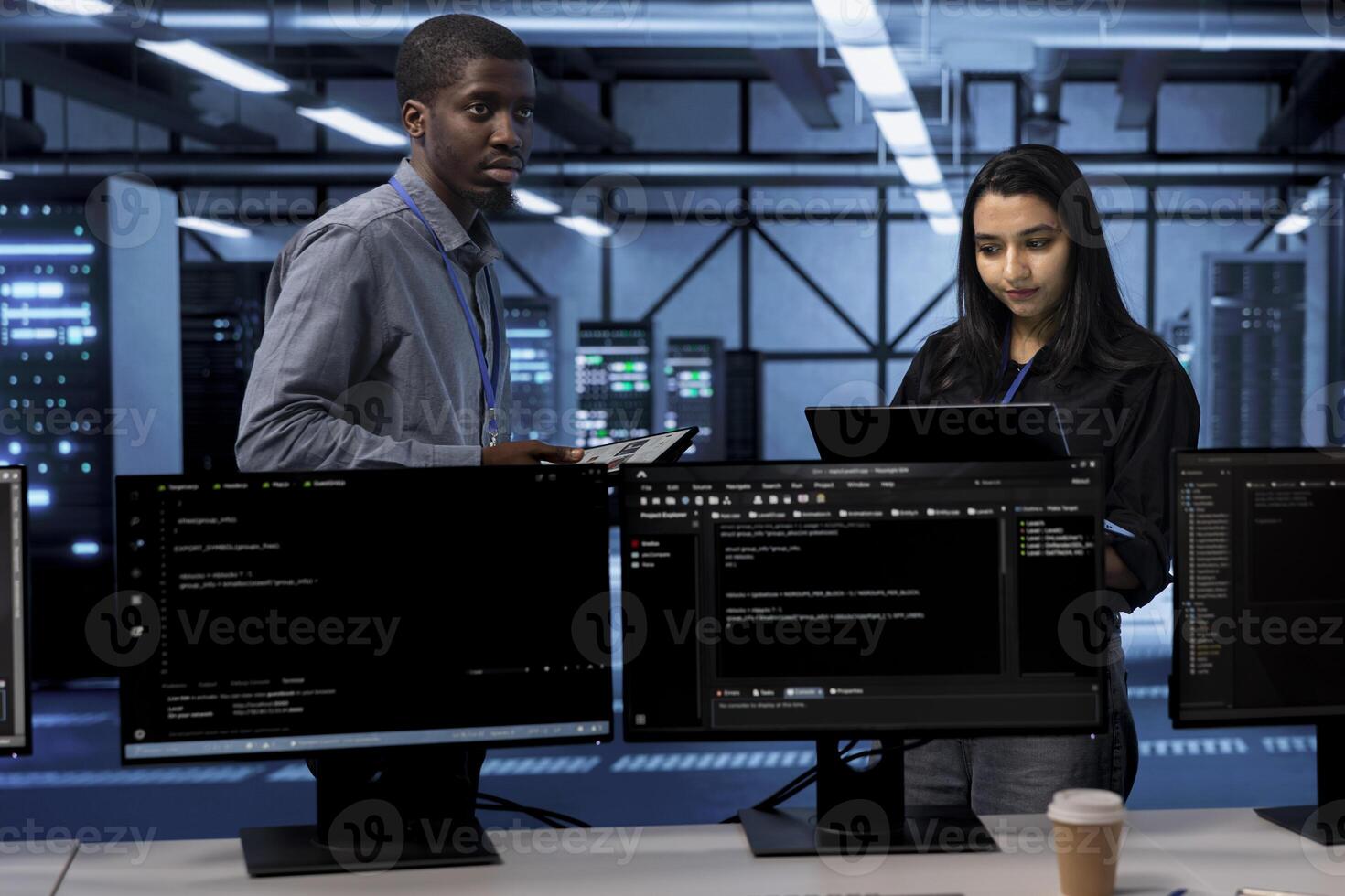 Technicians in data center using devices to check for server performance issues arising due to high CPU usage. Server farm staff members fixing insufficient memory errors slowing down hardware photo