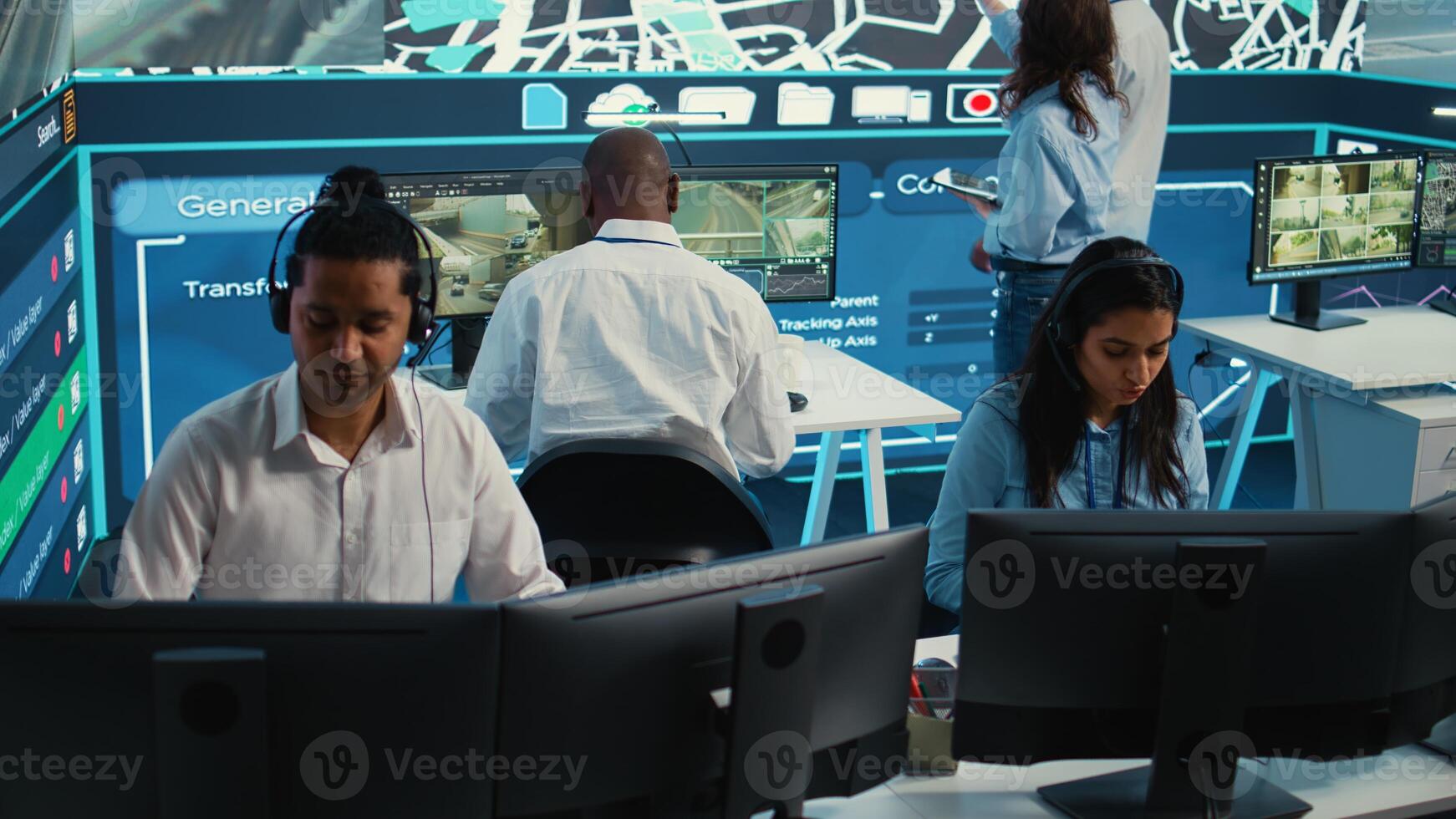 Indian woman dispatch operator gives directions to couriers, avoiding traffic by monitoring radar CCTV surveillance footage. Employee uses gps coordinates and satellite map. Camera B. photo