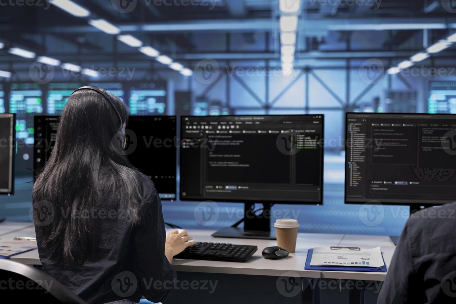 Software developer checking for signs of imminent failure in data center equipment. IT professional working at PC desk to preventing server rows damages, monitoring critical systems photo
