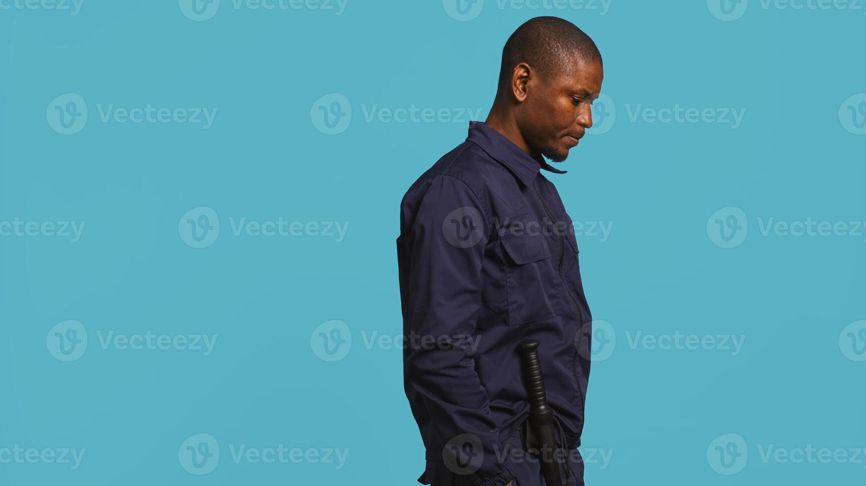 Bored security guard preventing criminal activity, patrolling around premises to deter criminals. Portrait of weary bodyguard walking around, lacking activity, studio background, camera B photo