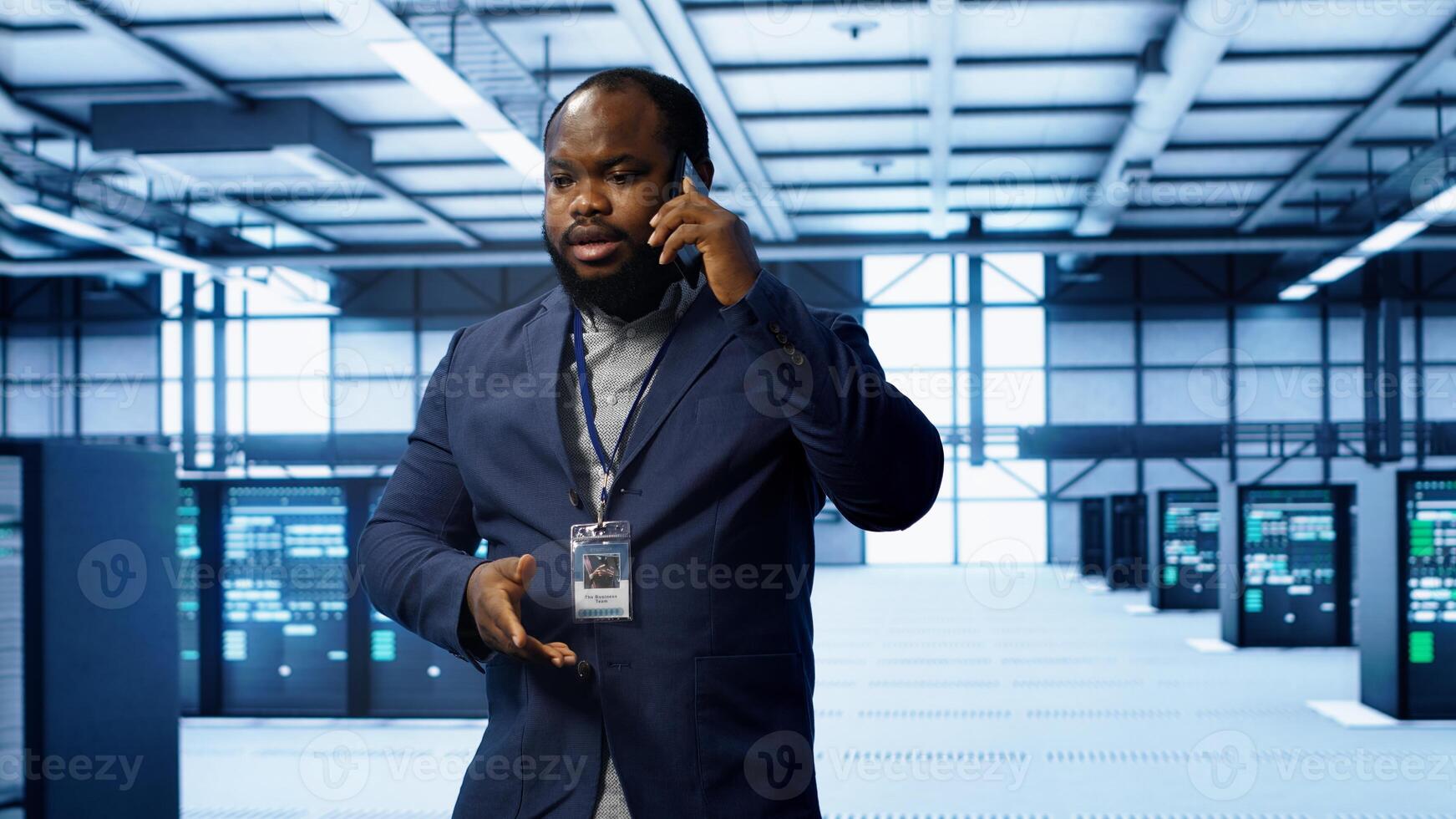 IT technician talking on phone in data center, coordinating server maintenance and troubleshooting tasks. Manager surrounded by server racks and high tech equipment in telephone call, camera A photo