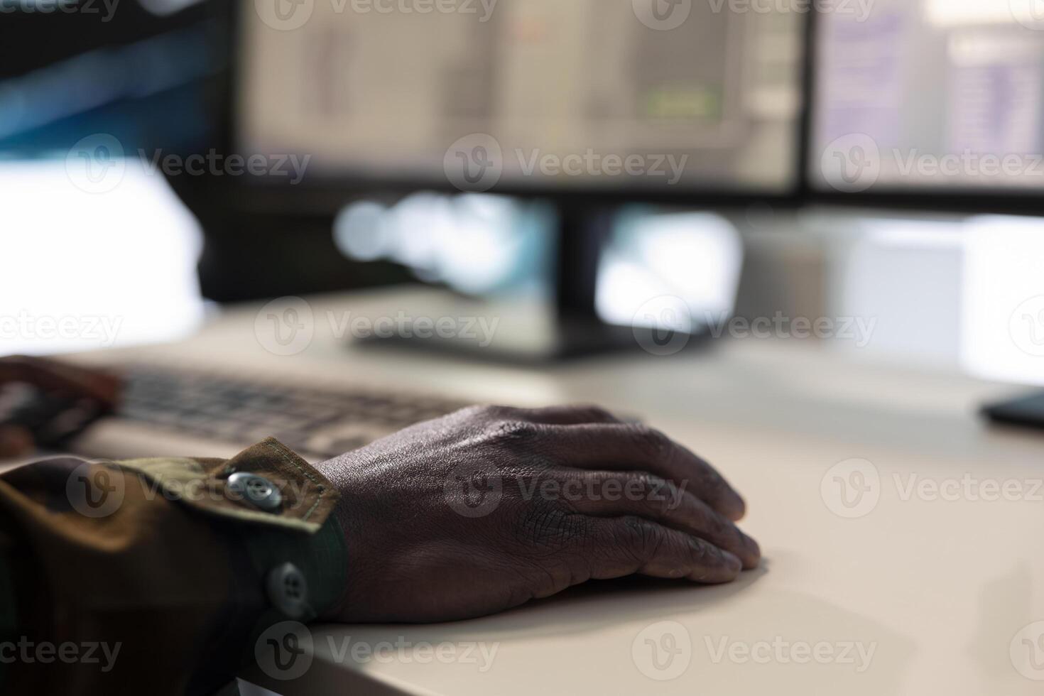 Military operations specialist following enemy vessels trajectory around the coast waters, working on ensuring protection via satellite surveillance system on computer. IT engineer. Close up. photo