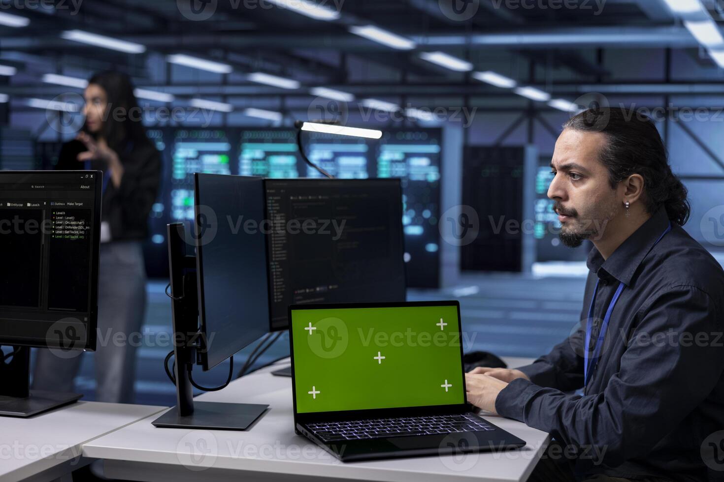 Admin using isolated screen notebook to oversee servers used for managing databases, hosting websites and storing files. Employee working on chroma key laptop in data center storing information photo