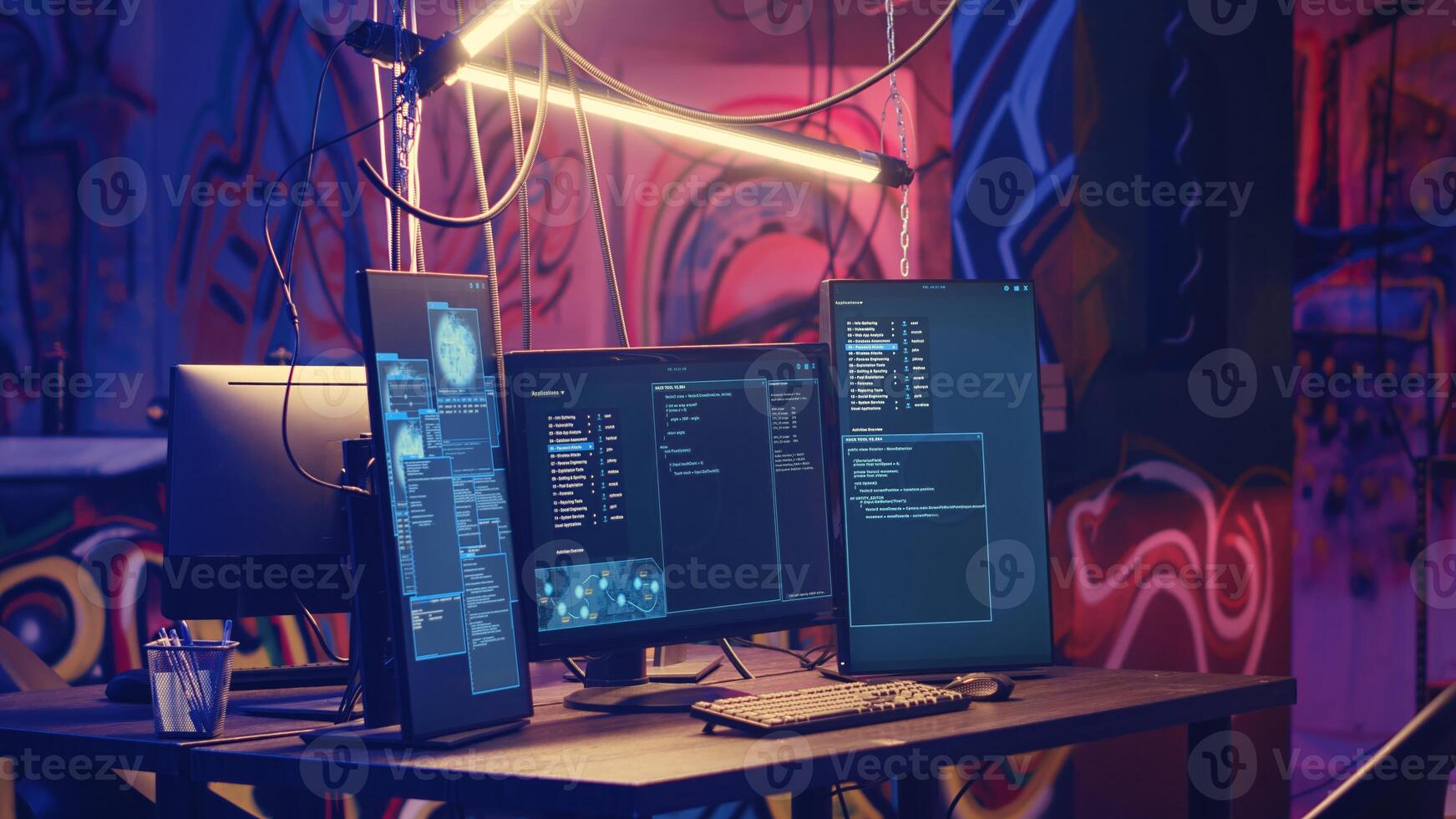 Computer screens with hacking script running in hidden underground HQ. PC monitors in neon lit empty warehouse used by hackers to escape from being arrested by law enforcement photo