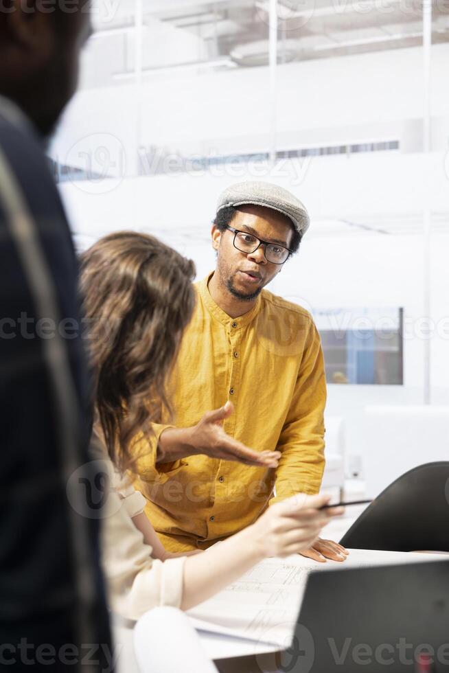 Realtor financier gives legal assistance to business clients regarding real estate investment plans, reviewing blueprints of a high class office space building. Rental agreement meeting. photo