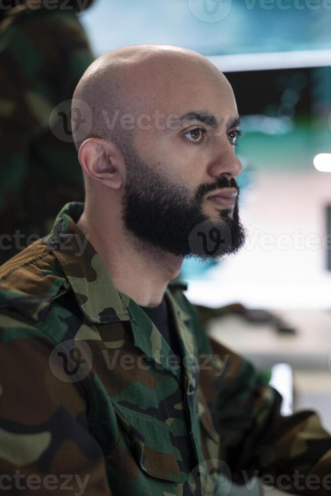 Army captain oversees special operation to gather intelligence, analyzing important data for a national defense mission. Major targeting enemy vessels on radar CCTV system in power base. photo