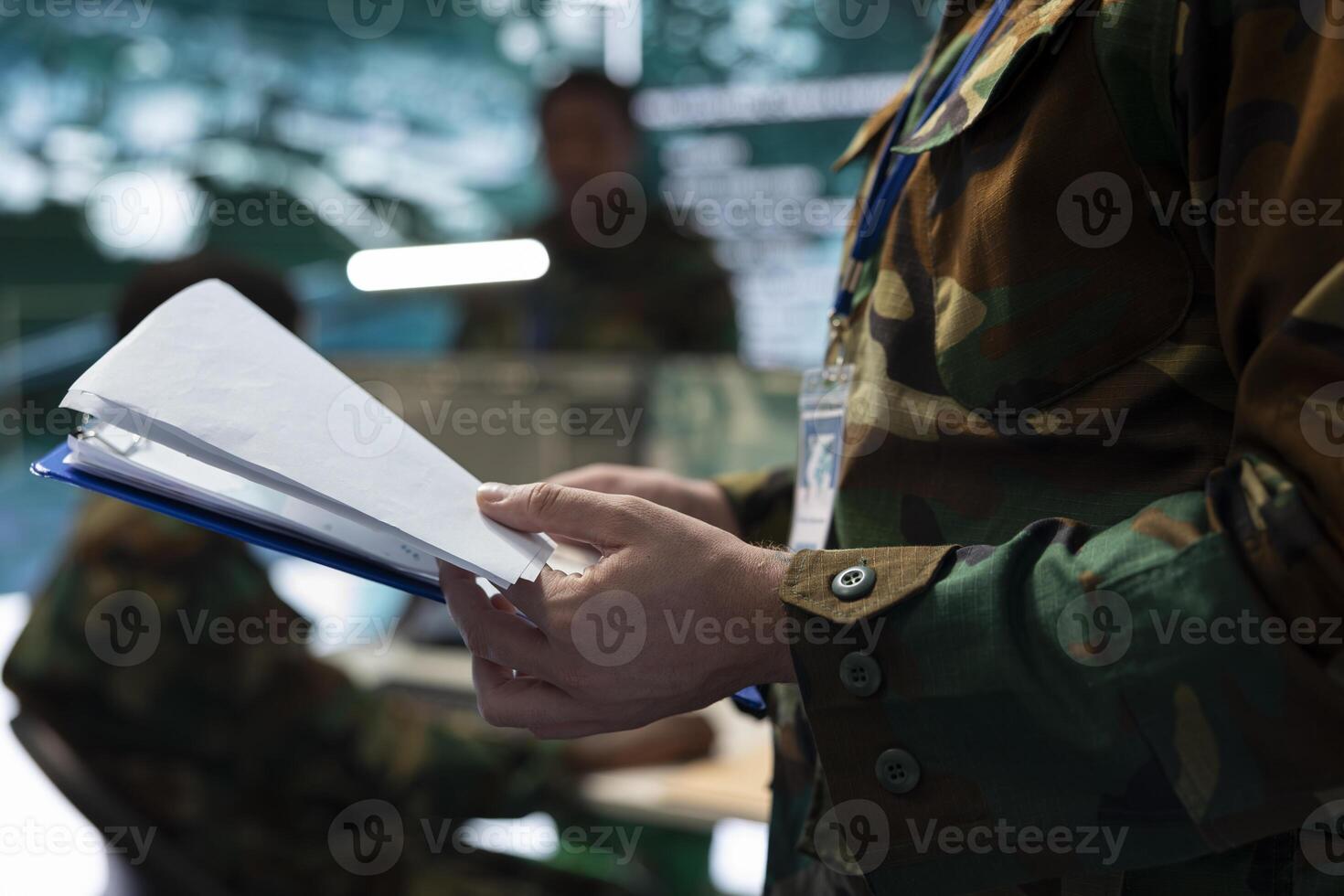 Trooper analyzes federal case file for a new national safety mission, studying defense tactics and objectives before briefing the recruits. Army specialist making attack plans to ensure success. photo