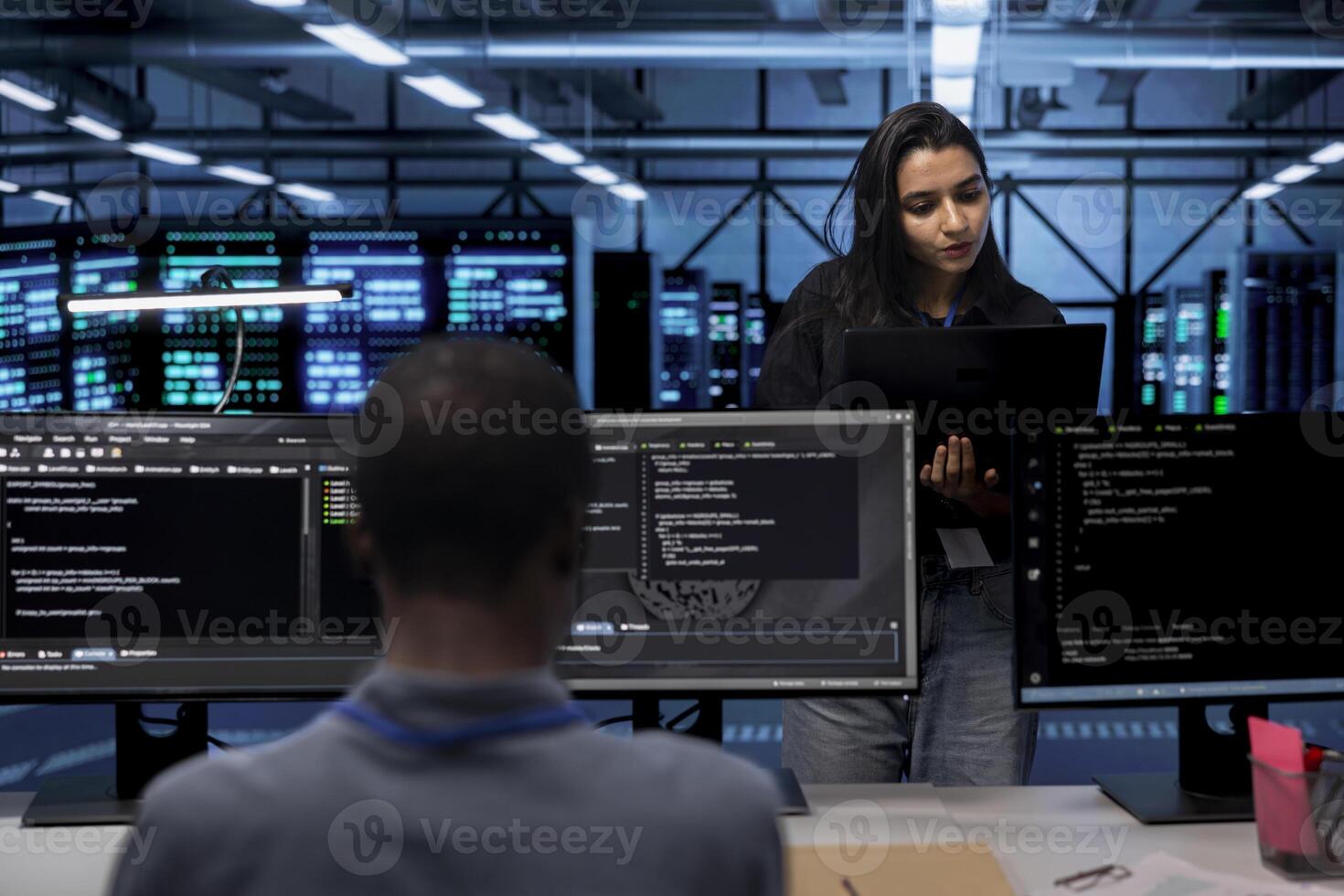 Computer scientists in data center running system diagnostic tests on laptop to fix problems. IT professionals in server room deploying error checking utilities on notebook to fix network issues photo