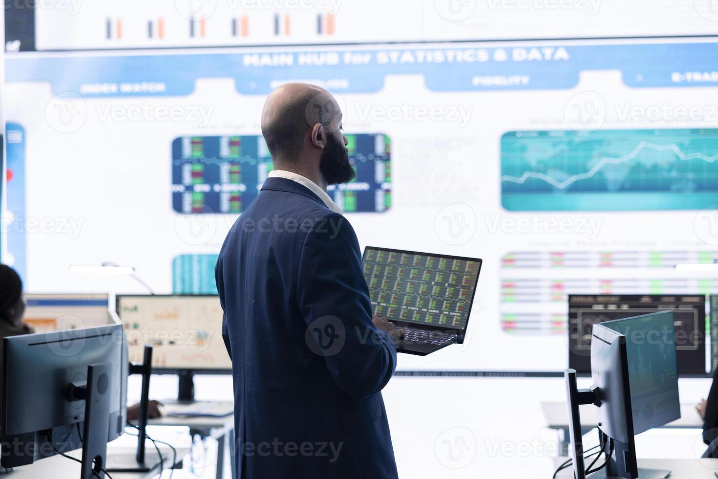 Administrative assistant examining important big data visualizations on a huge display, creating an analysis to review key performance indicators and business efficiency in office. photo