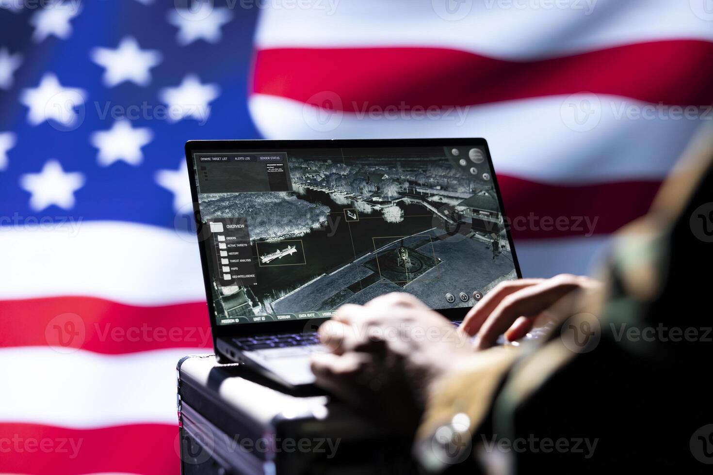 United States military officer using target acquisition software on notebook to detect enemy location. Close up shot of soldier isolated over USA flag using satellite gear to identify terrorists photo