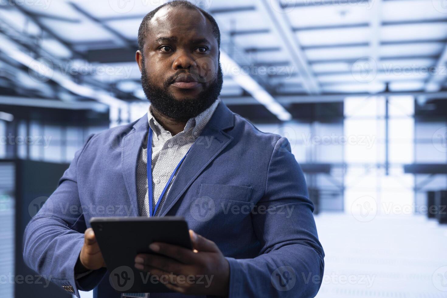 Technician in data center using device to identify and solve technical issues related to data center infrastructure. IT specialist managing, maintaining and securing server hub environment photo