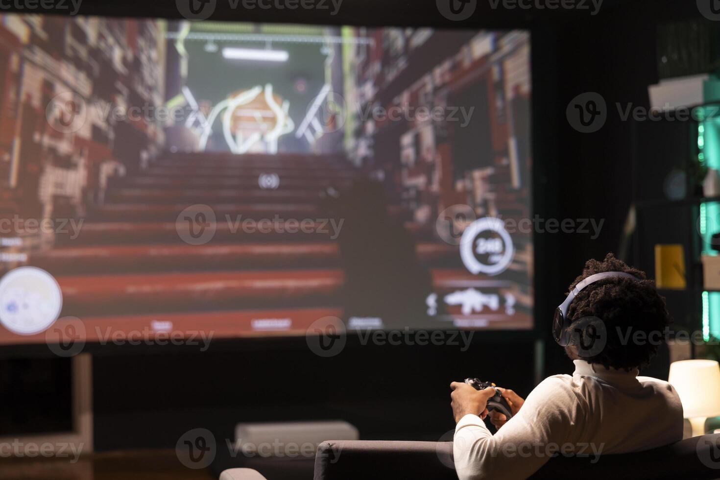 Gamer using headphones microphone to discuss with teammates while playing science fiction game on large smart TV. Player in apartment entertained by SF videogame on console, using joystick controller photo