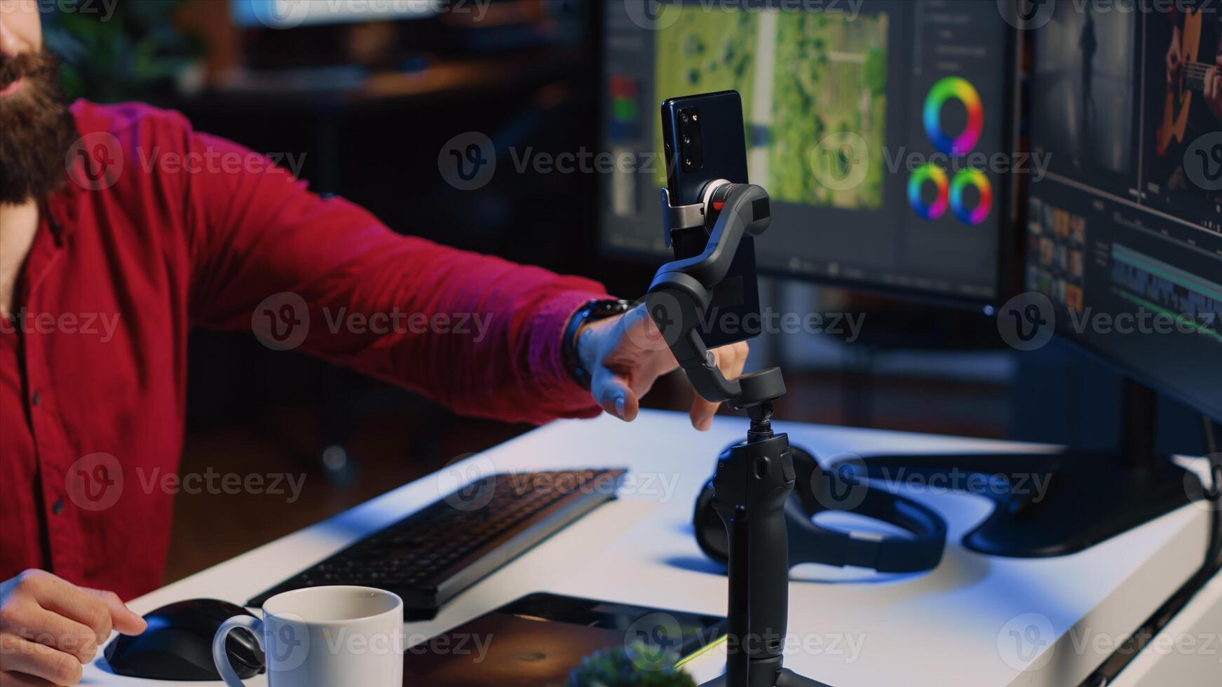 Videography content creator livestreaming using smartphone, talking with audience about elevating quality with skillful editing techniques. Media production influencer chats with viewers photo