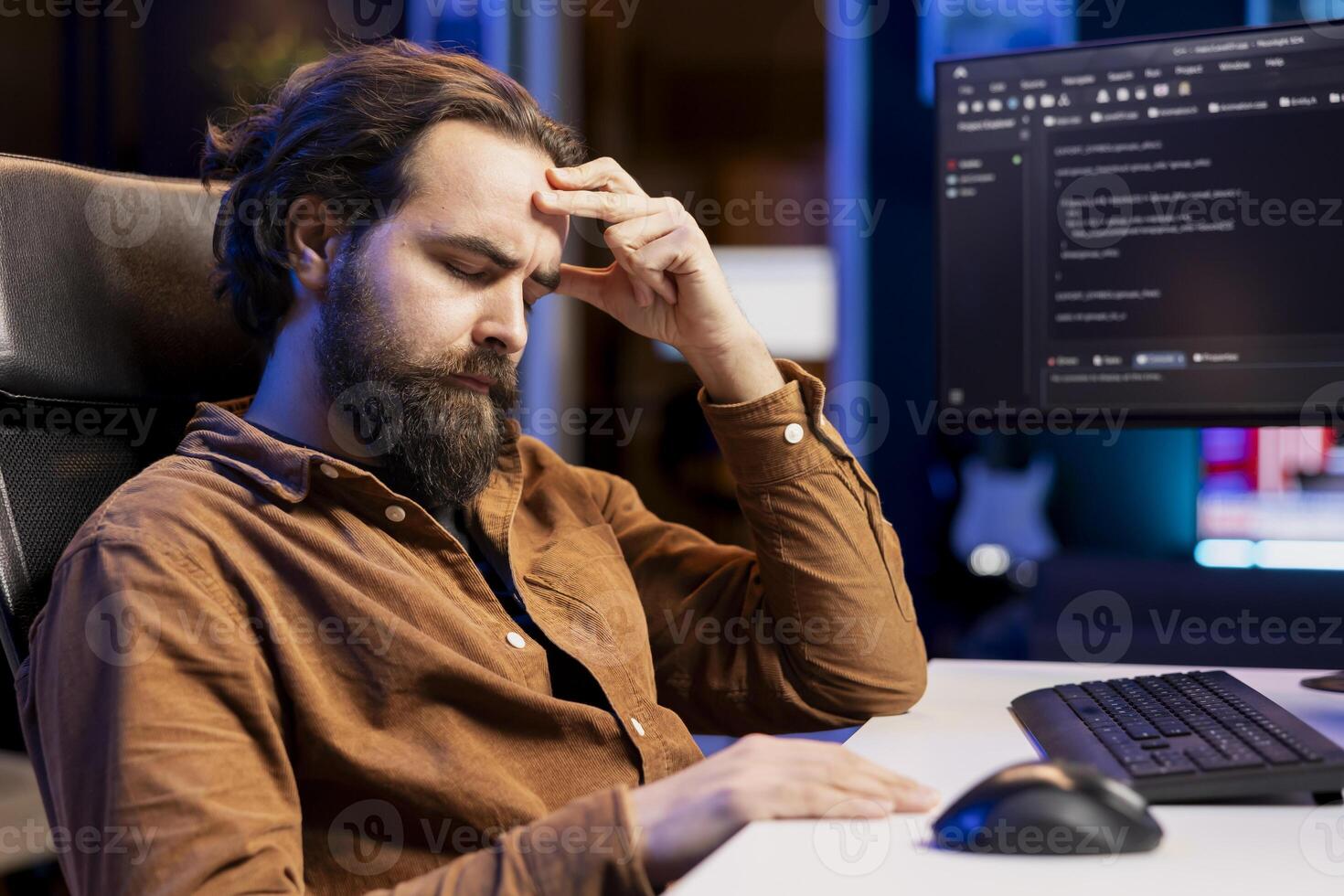 Tired man hurting from too much stress accumulated while doing software quality assurance, reading source code on computer. Developer suffers from headache after inspecting coding on PC for too long photo