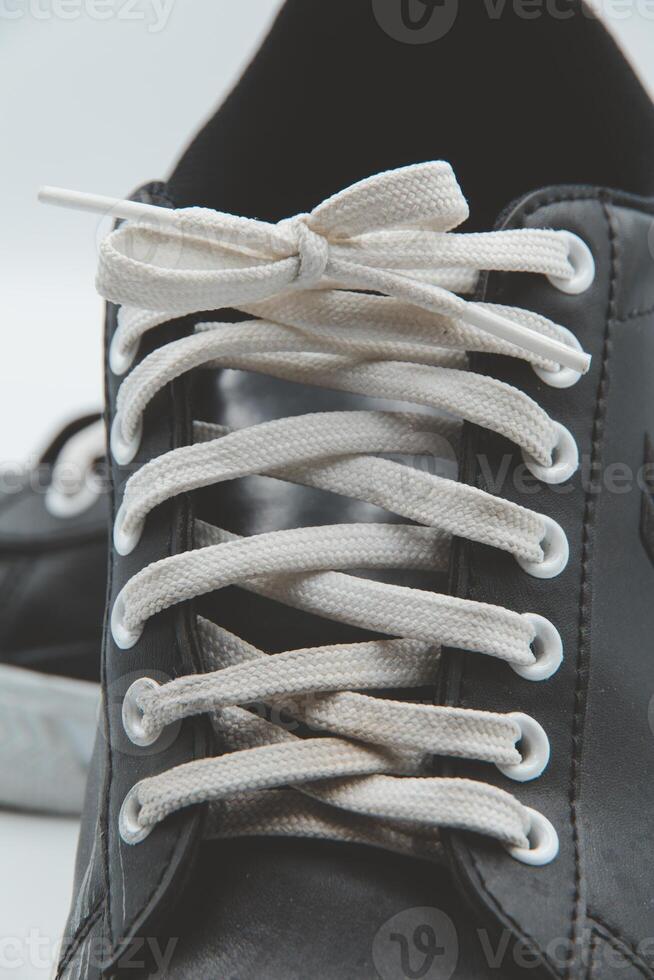 shoe sneaker on white background, close up of sneaker on white background, old black generic sneakers on white background. photo