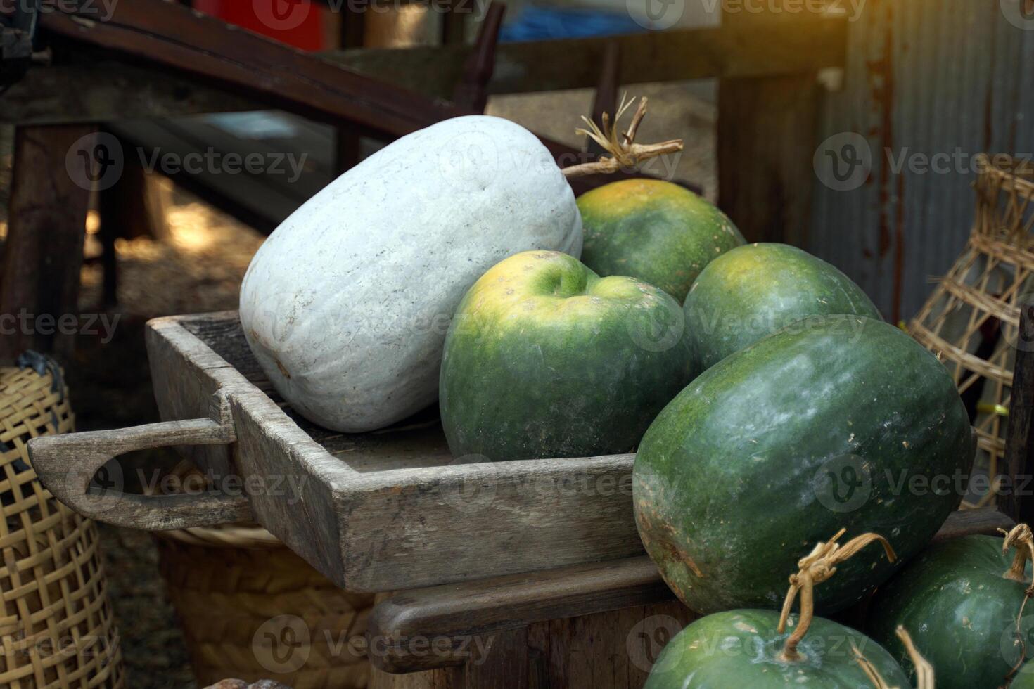 Ash gourd on a wooden tray is a herbaceous vine. The fruit is cylindrical in shape and has a rounded tip. It is commonly used in Asian cooking. photo