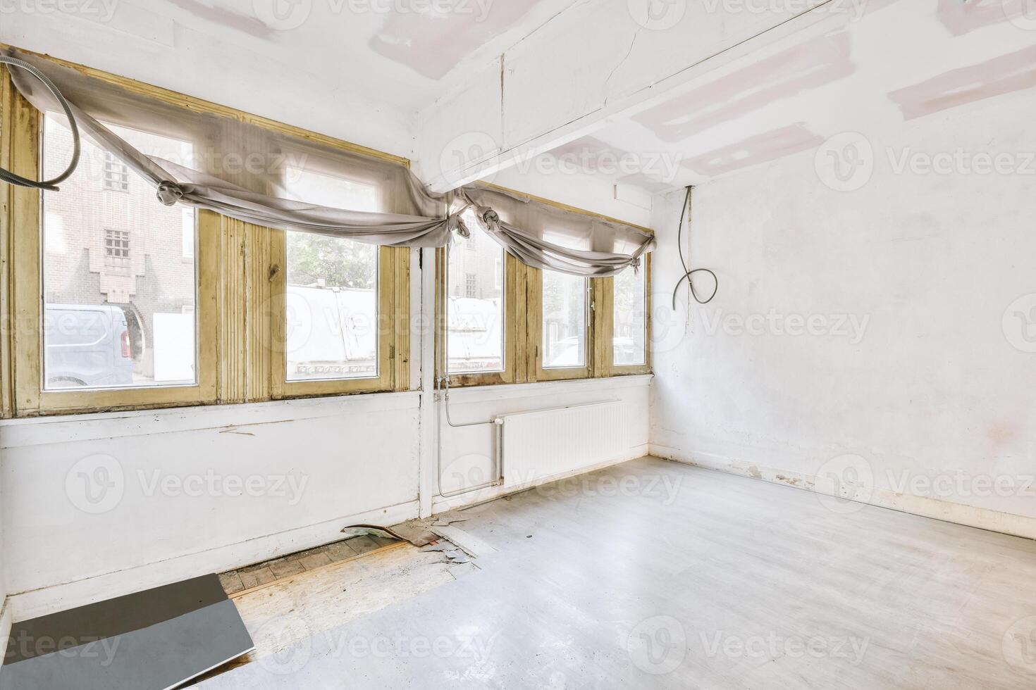 An empty room with a window and a floor photo