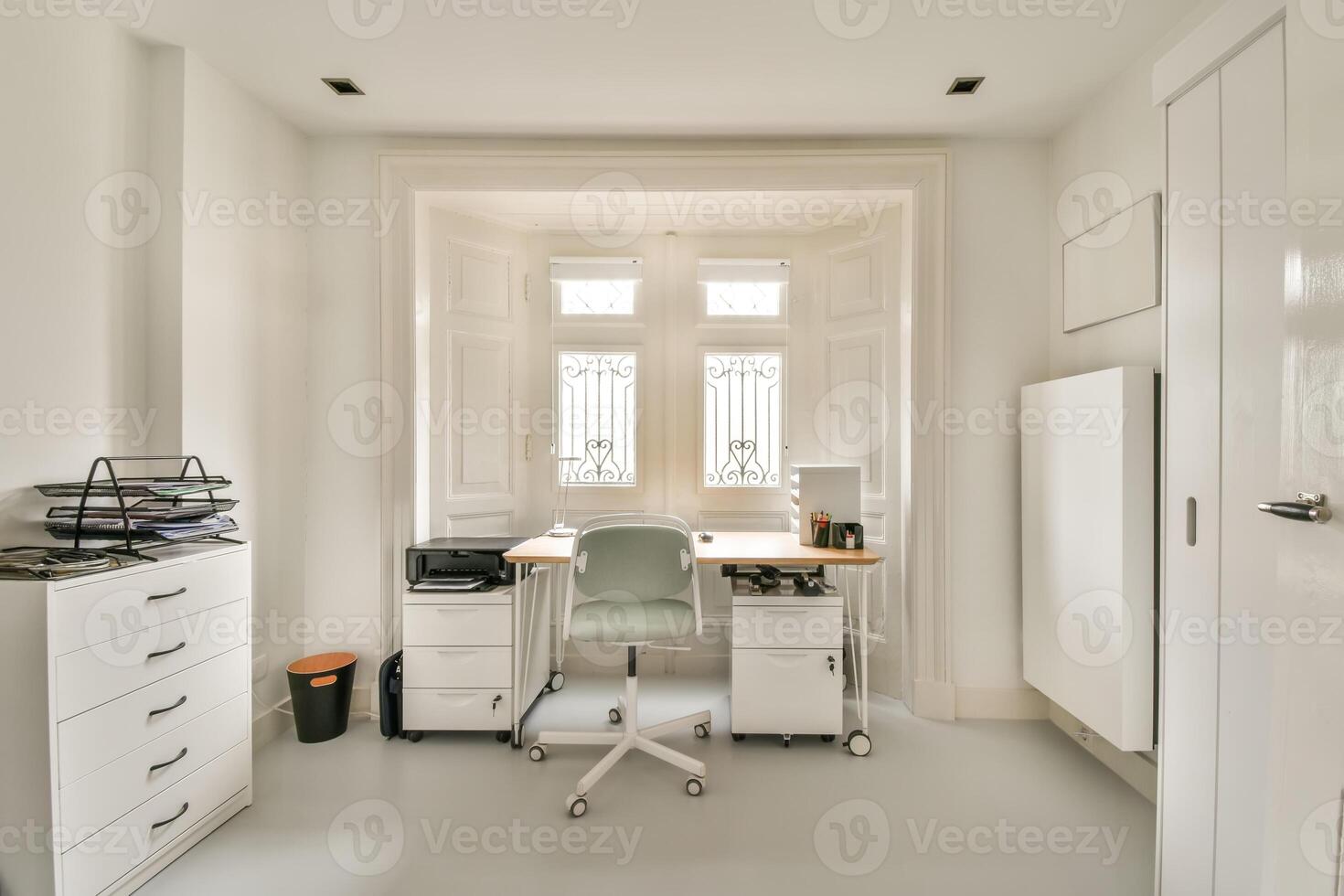 A home office with a desk, chair and a window photo