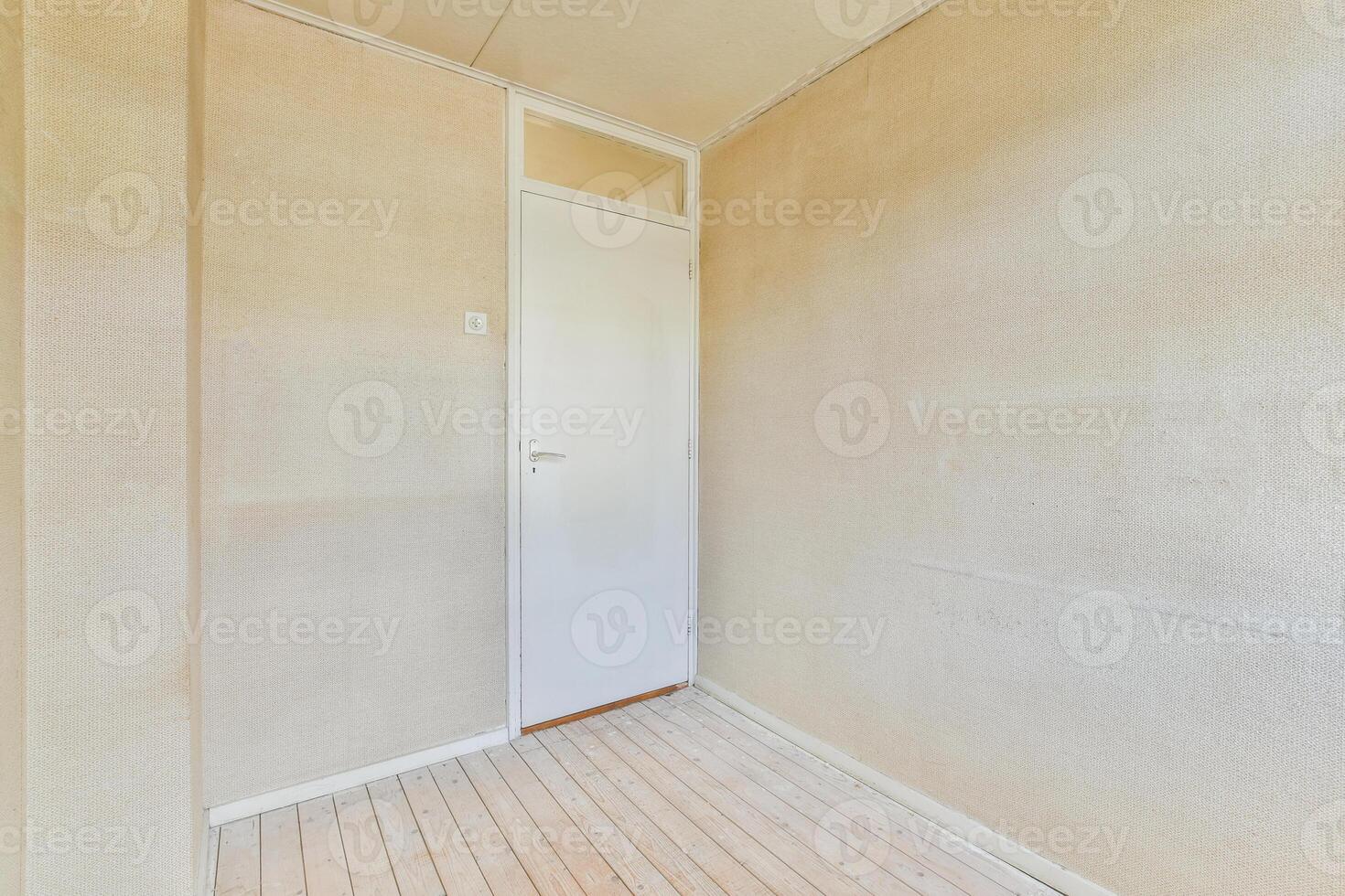 An empty room with a door and a wooden floor photo