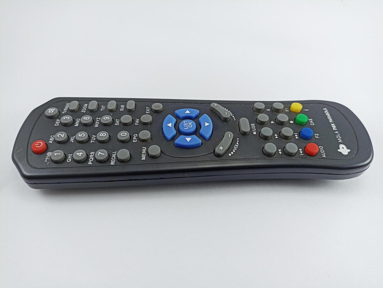 Wonosobo, Central Java Indonesia - August 9 2024 a black TV remote control from the Mola Nex satellite dish on a white background photo