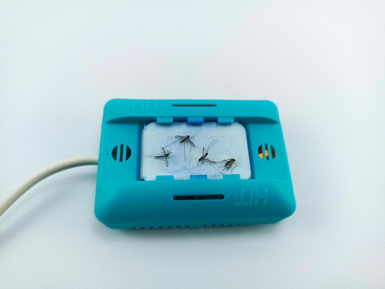Wonosobo, Central Java, Indonesia - 06 September 2024 use of an electric anti-mosquito fumigator on a white background. several mosquitoes died on the device photo
