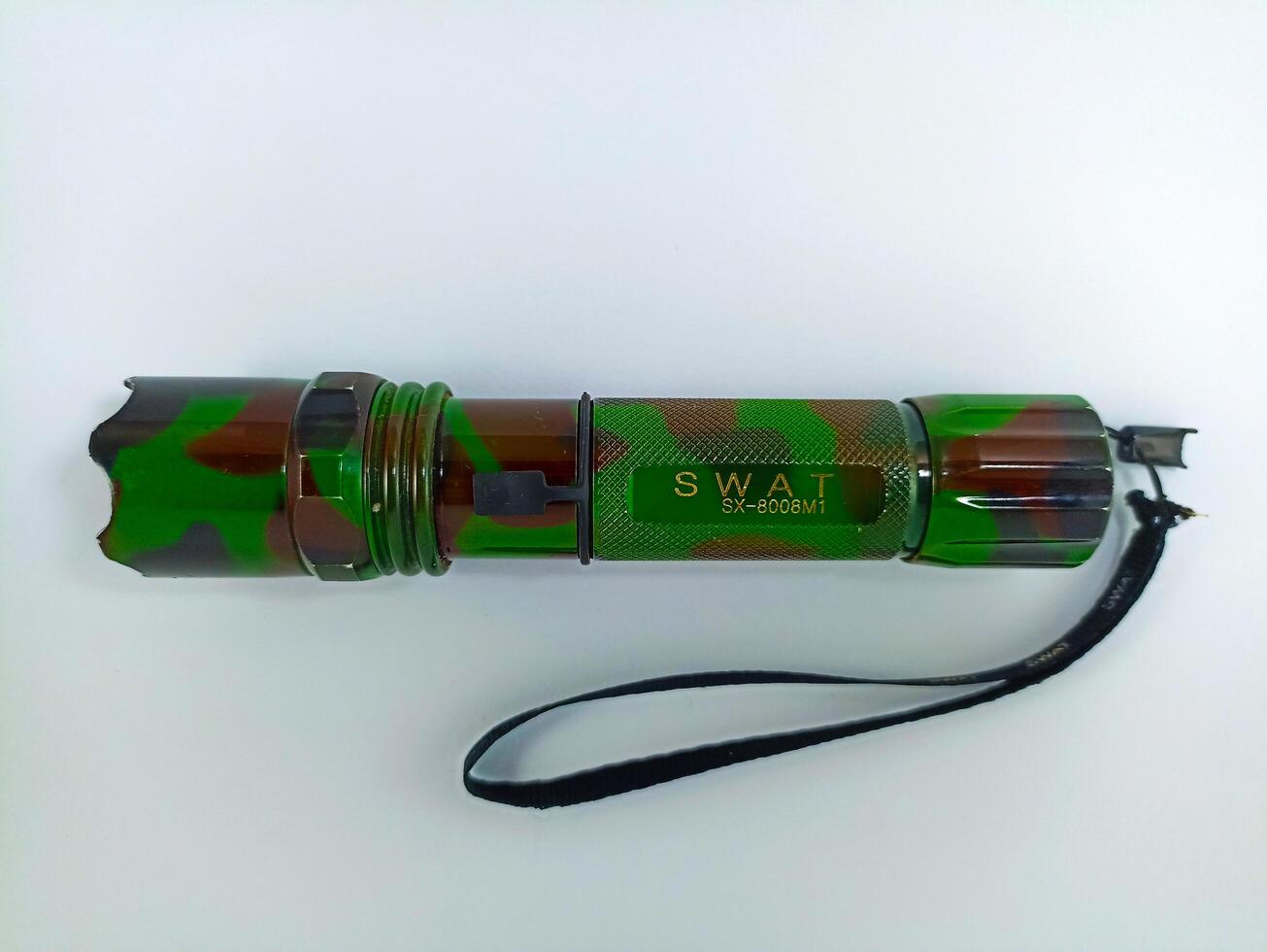 Wonosobo, Central Java, Indonesia - September 7, 2024 Detail of a sturdy green Swat flashlight on a white background. This is a flashlight with a magnifier, waterproof and ready for the toughest jobs photo