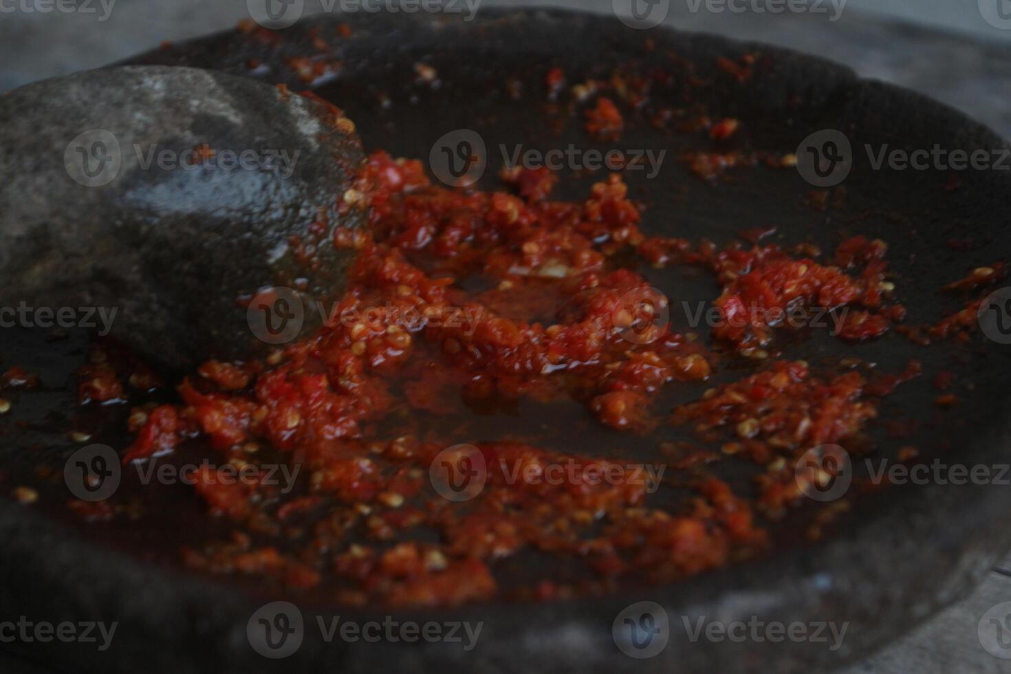 Sambal cobek or traditional Indonesian chili sauce, made from chilies, spices and other kitchen spices. made using a stone mortar and pestle. suitable for menu books. photo