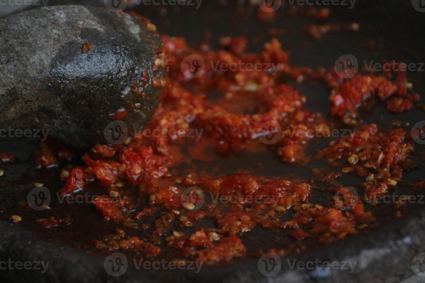 Sambal cobek or traditional Indonesian chili sauce, made from chilies, spices and other kitchen spices. made using a stone mortar and pestle. suitable for menu books. photo