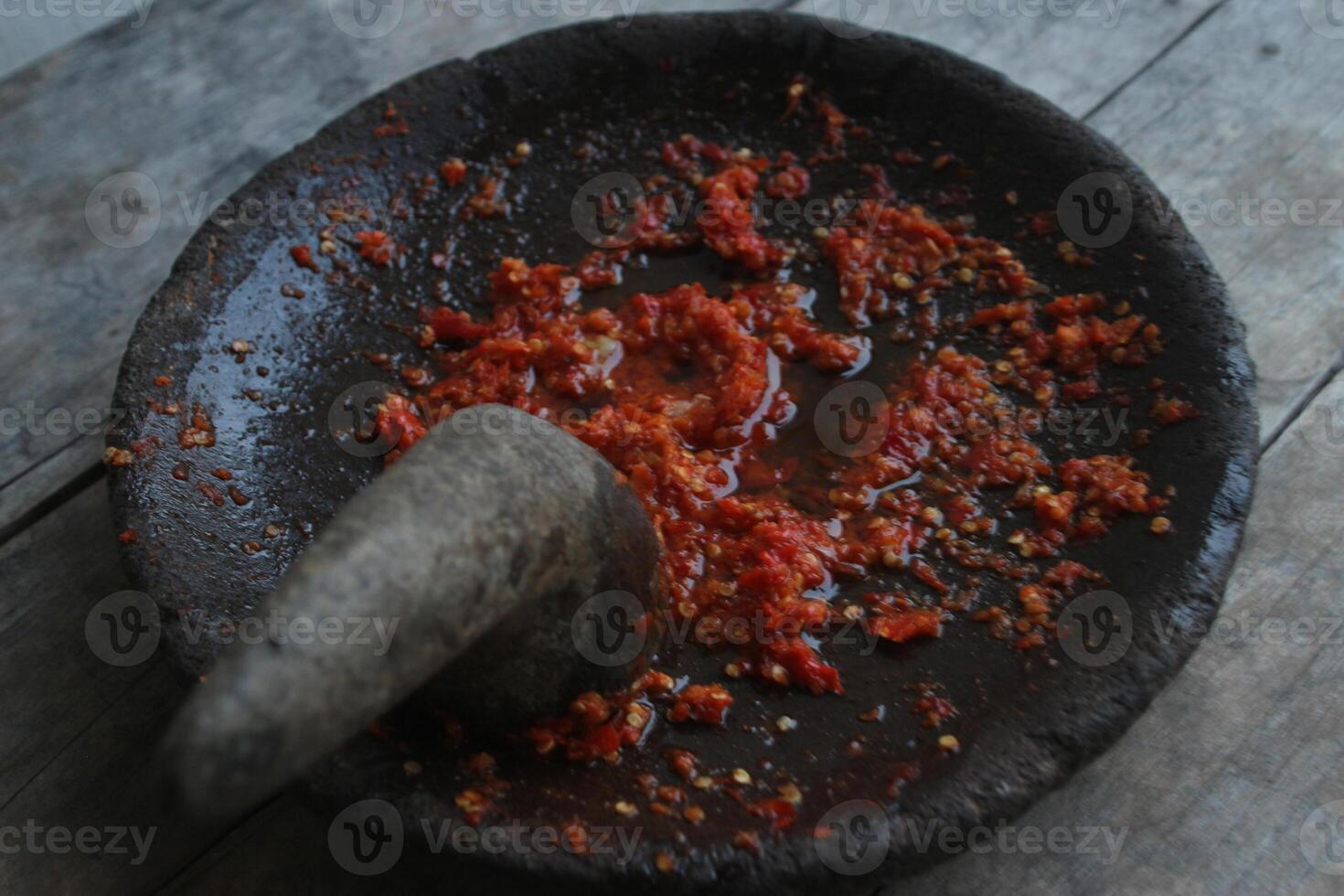 Sambal cobek or traditional Indonesian chili sauce, made from chilies, spices and other kitchen spices. made using a stone mortar and pestle. suitable for menu books. photo